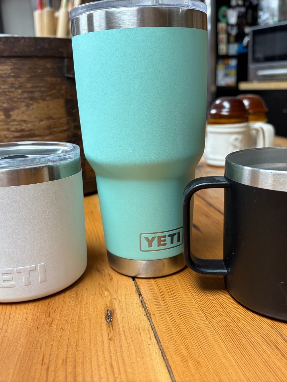 3 Yeti white insulated mug with seafoam green white and Black tumbler visible
